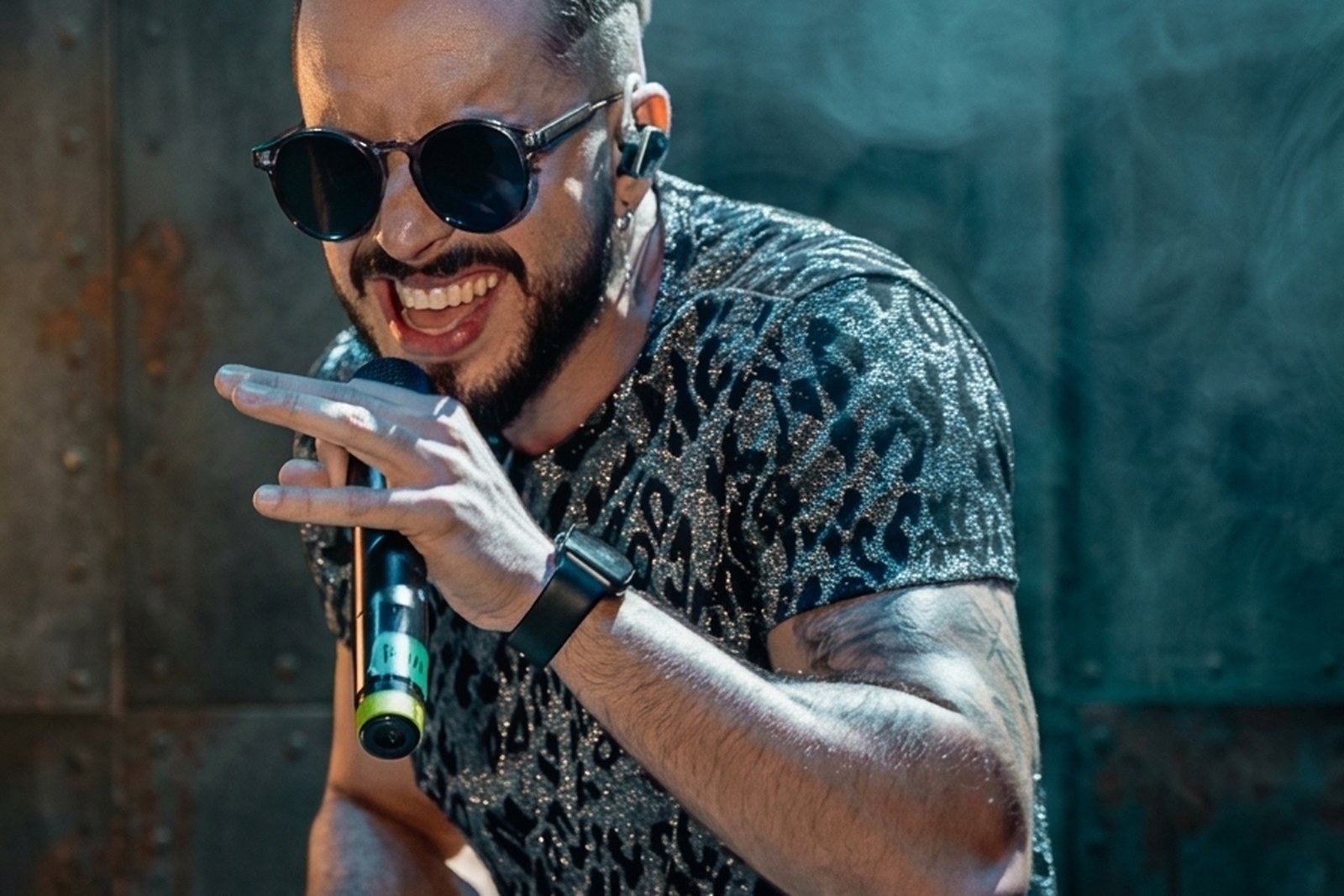 Ronie Suárez no palco durante um show, sob iluminação cênica.