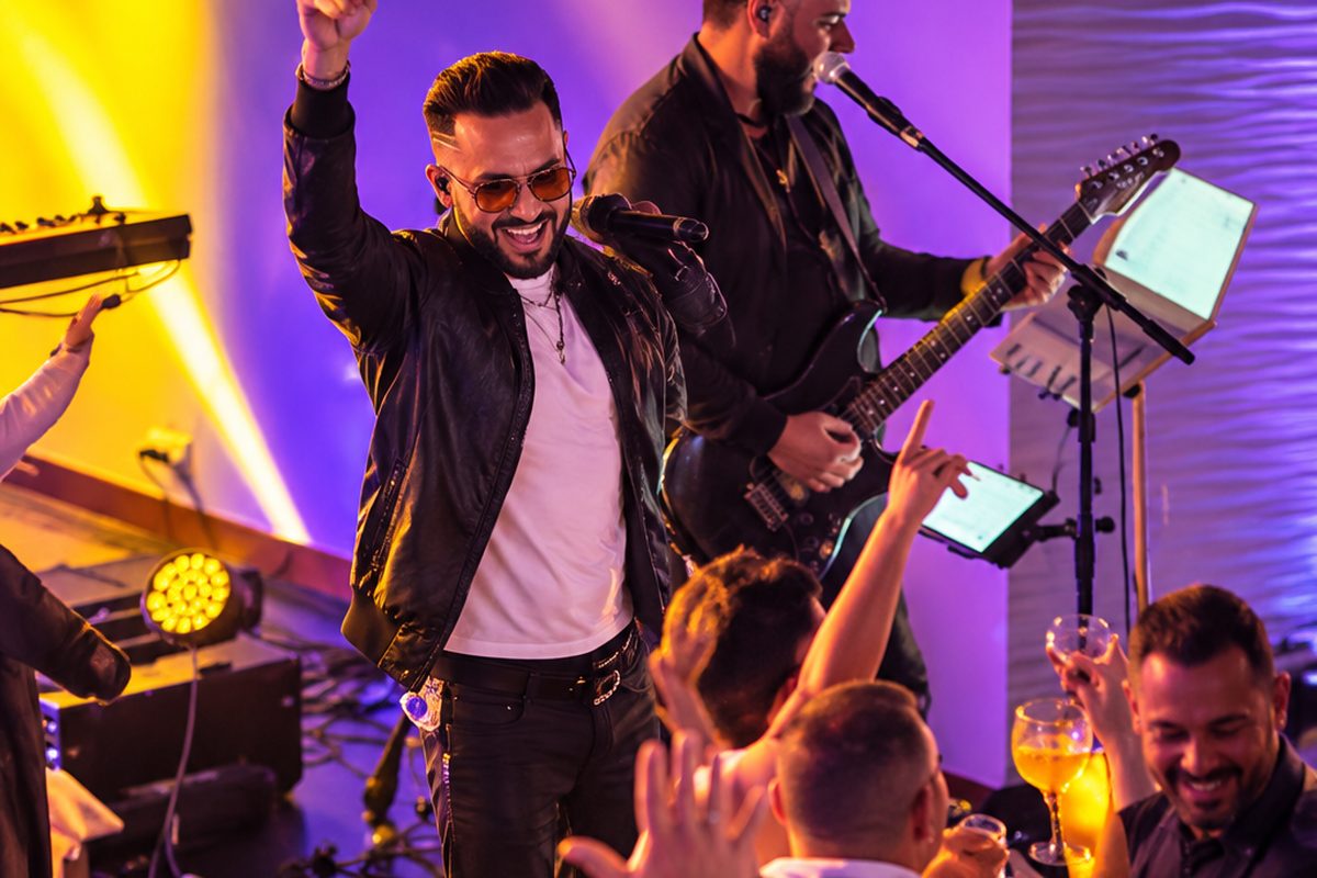 Ronie Suárez com a banda animando o público de perto no palco.